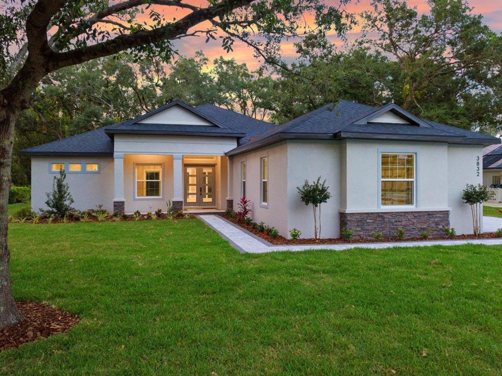 3832 Little Country Road Parrish, FL 34219 - Photo 1 of 1 Front Exposure featuring stone siding with a large front yard, paver driveway, walkway, and porch