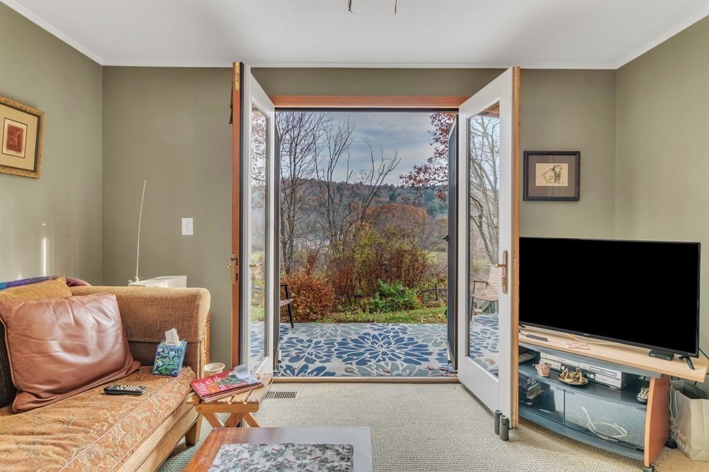 149 Boston Road Palmer, MA 01069 - Photo 20 of 35 a living room with furniture a flat screen tv and a floor to ceiling window