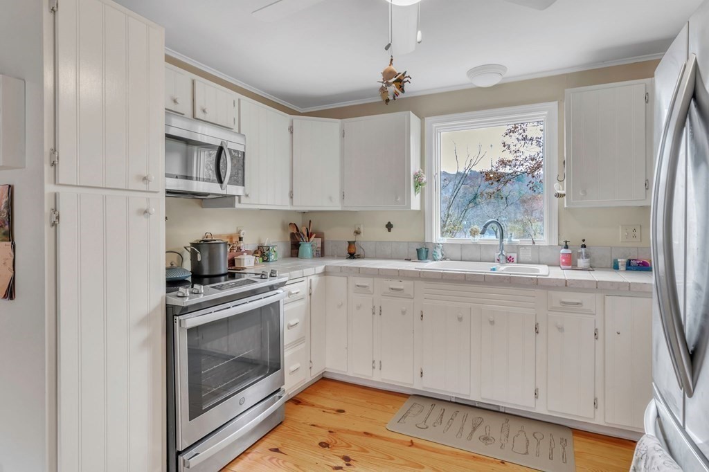 149 Boston Road Palmer, MA 01069 - Photo 10 of 35 a kitchen with stainless steel appliances granite countertop a sink a stove a refrigerator and cabinets