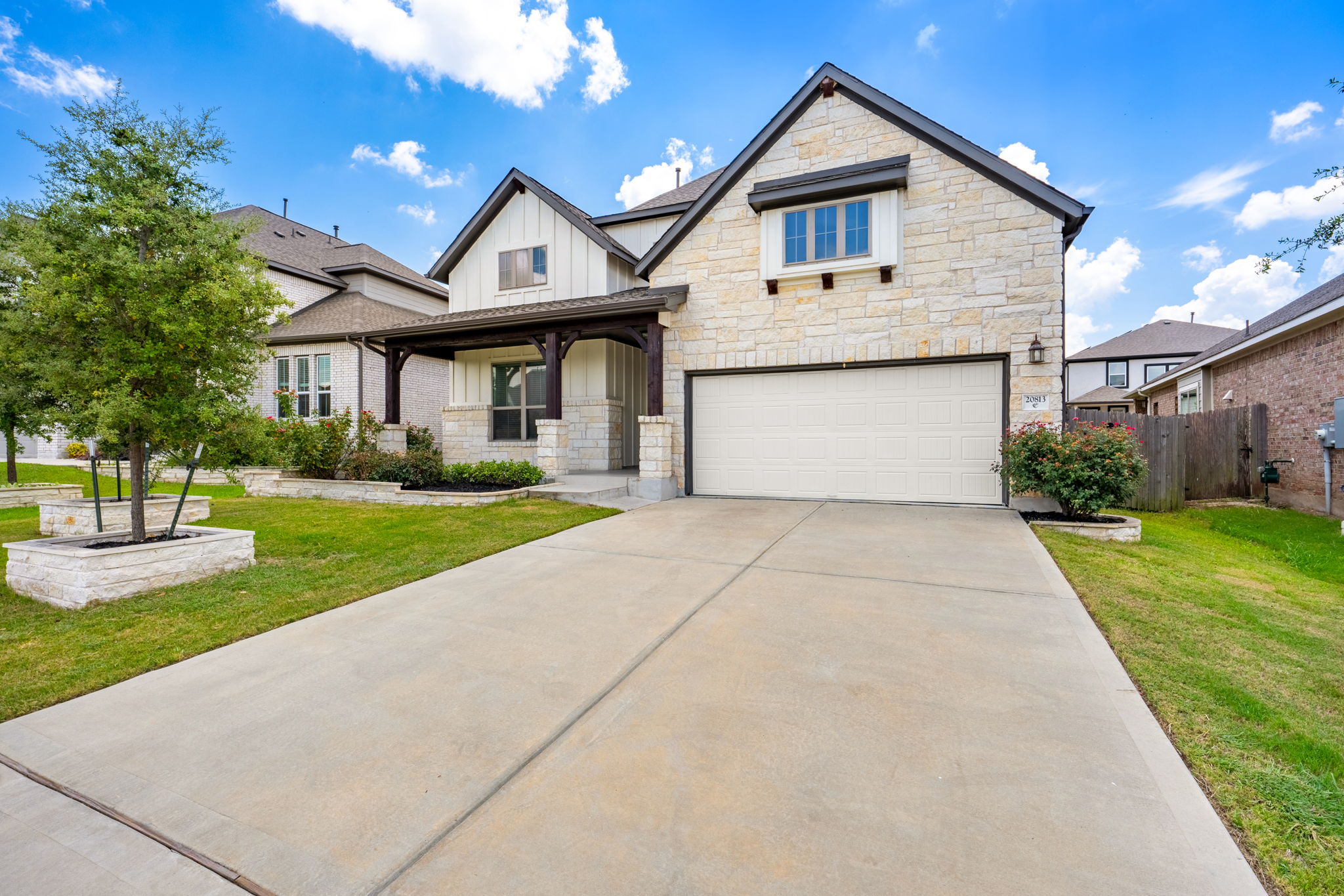 20813 Carries Ranch Road Pflugerville, TX 78660 - Photo 2 of 40 A spacious concrete driveway leads to the integrated two-car garage of this beautiful stone home.