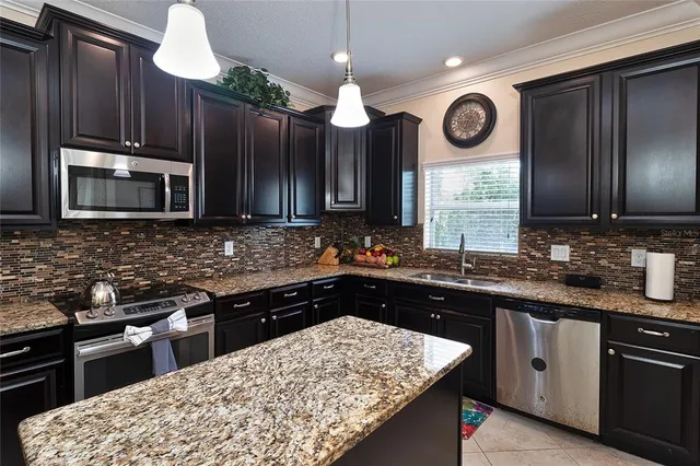 a kitchen with stainless steel appliances wooden cabinets a refrigerator and a sink