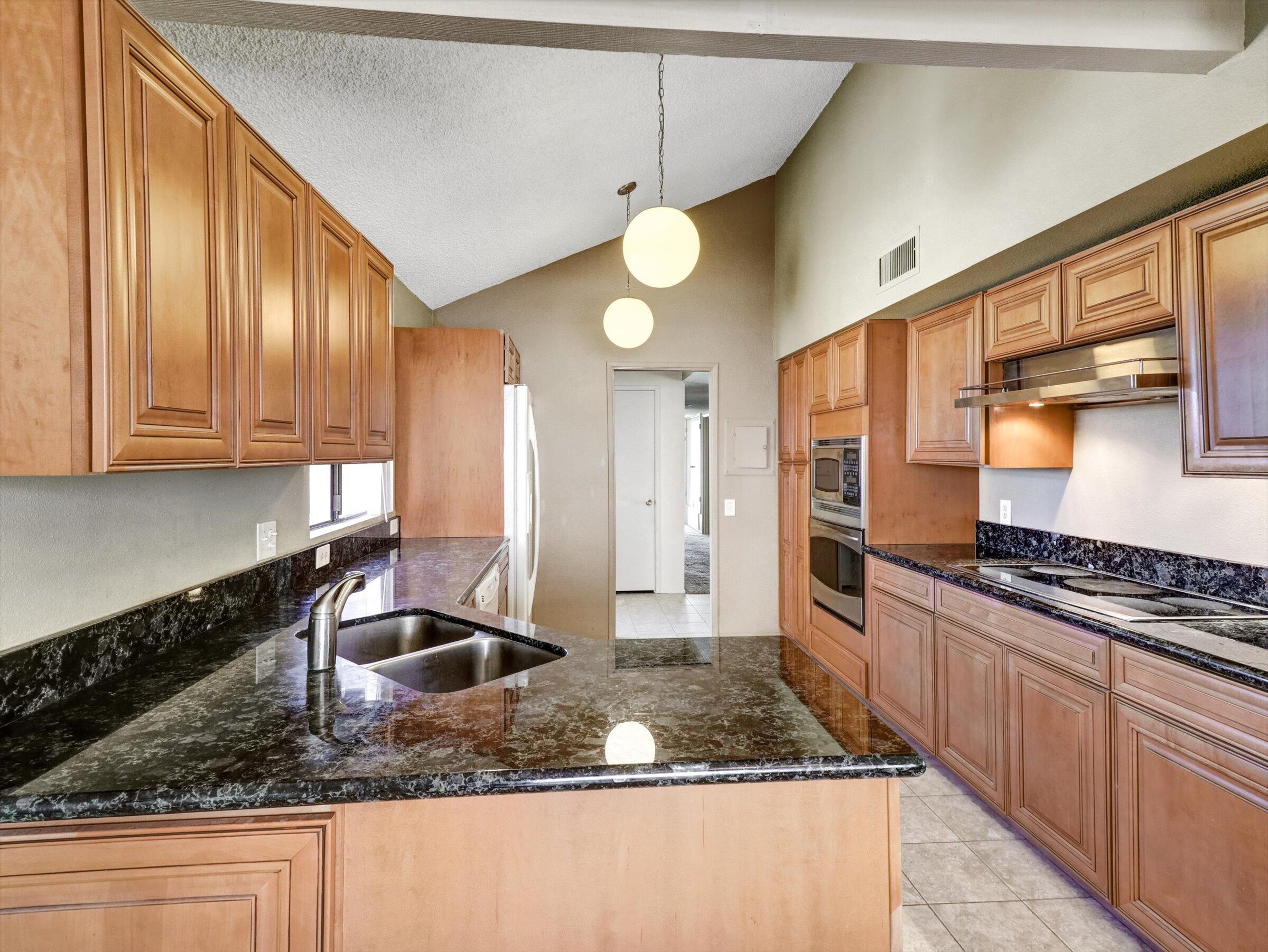 67805 Foothill Road Cathedral City, CA 92234 - Photo 9 of 22 a kitchen with stainless steel appliances granite countertop a sink a stove cabinets counter space and a window