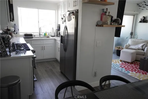 a kitchen with a refrigerator a stove a sink and a potted plant