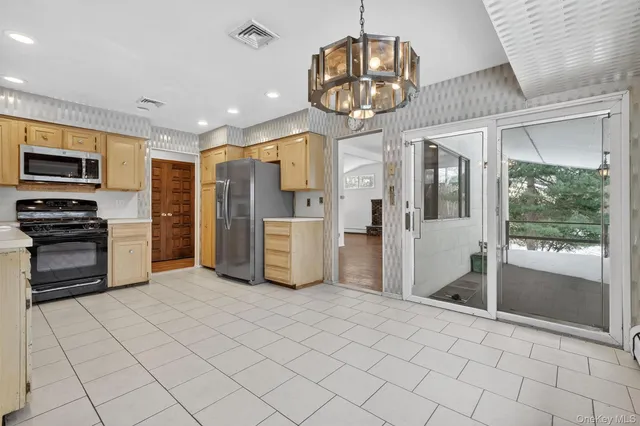a kitchen with stainless steel appliances granite countertop a refrigerator and a stove top oven