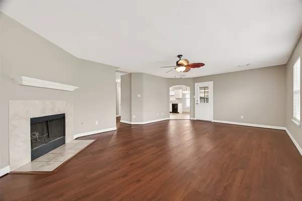 a view of empty room with wooden floor and fireplace