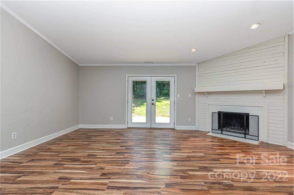 3415 Spring Terrace Lane Charlotte, NC 28269 - Photo 4 of 23 a view of empty room with wooden floor and fireplace
