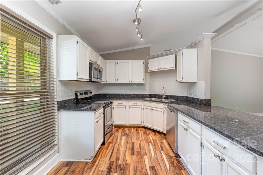 3415 Spring Terrace Lane Charlotte, NC 28269 - Photo 9 of 23 a kitchen with stainless steel appliances granite countertop a sink and cabinets