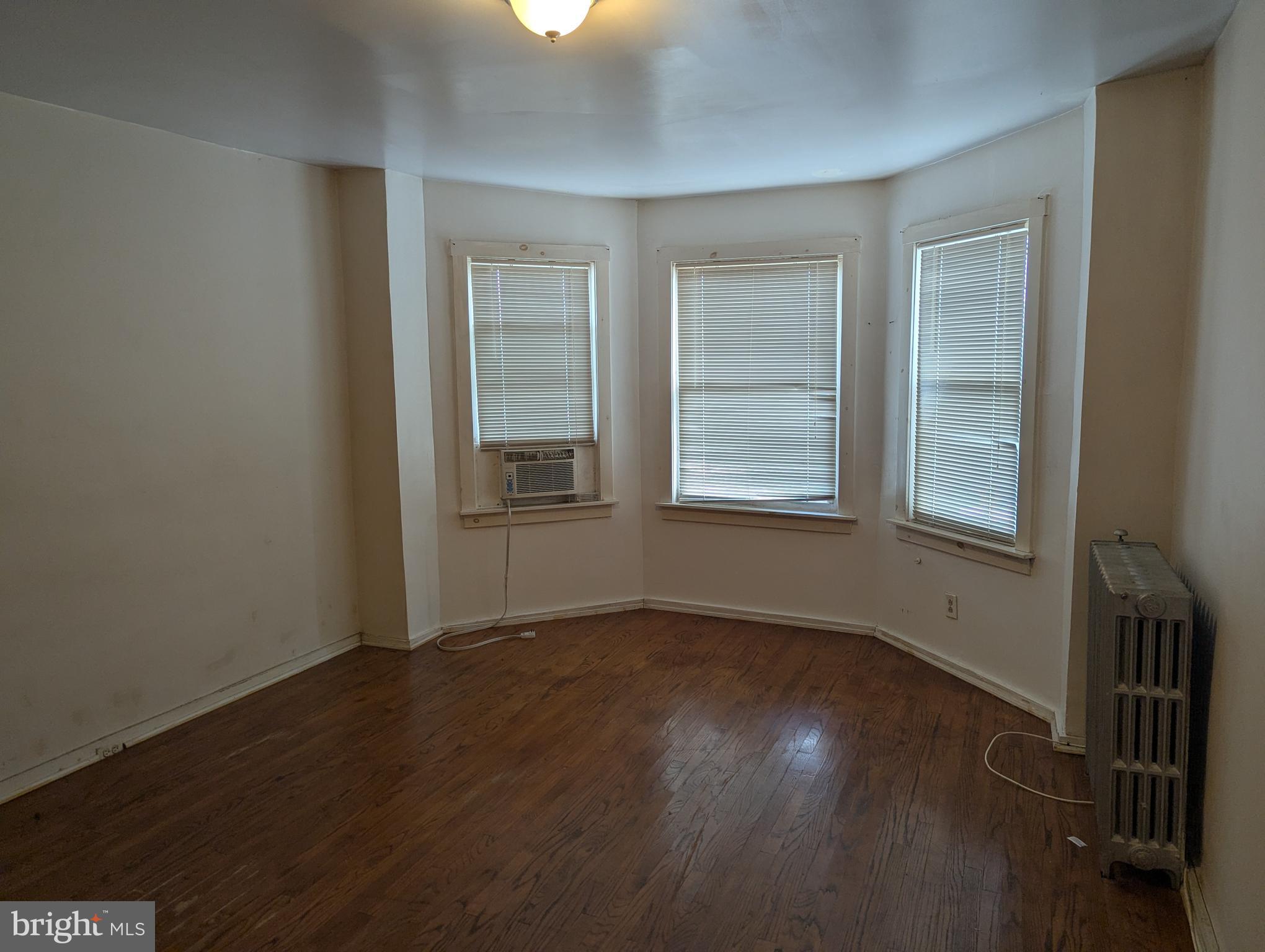 3442 Belair Road Baltimore, MD 21213 - Photo 11 of 27 an empty room with wooden floor and windows
