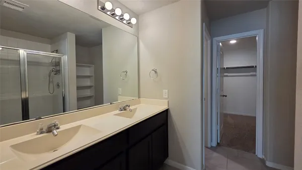 a bathroom with a double vanity sink mirror and shower