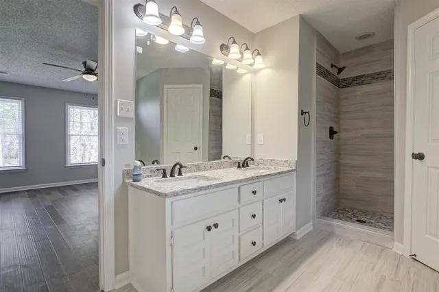 a bathroom with a double vanity sink mirror and shower