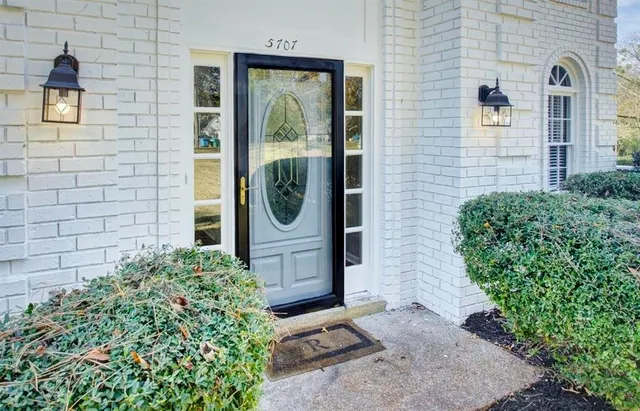 a view of a brick house with potted plants