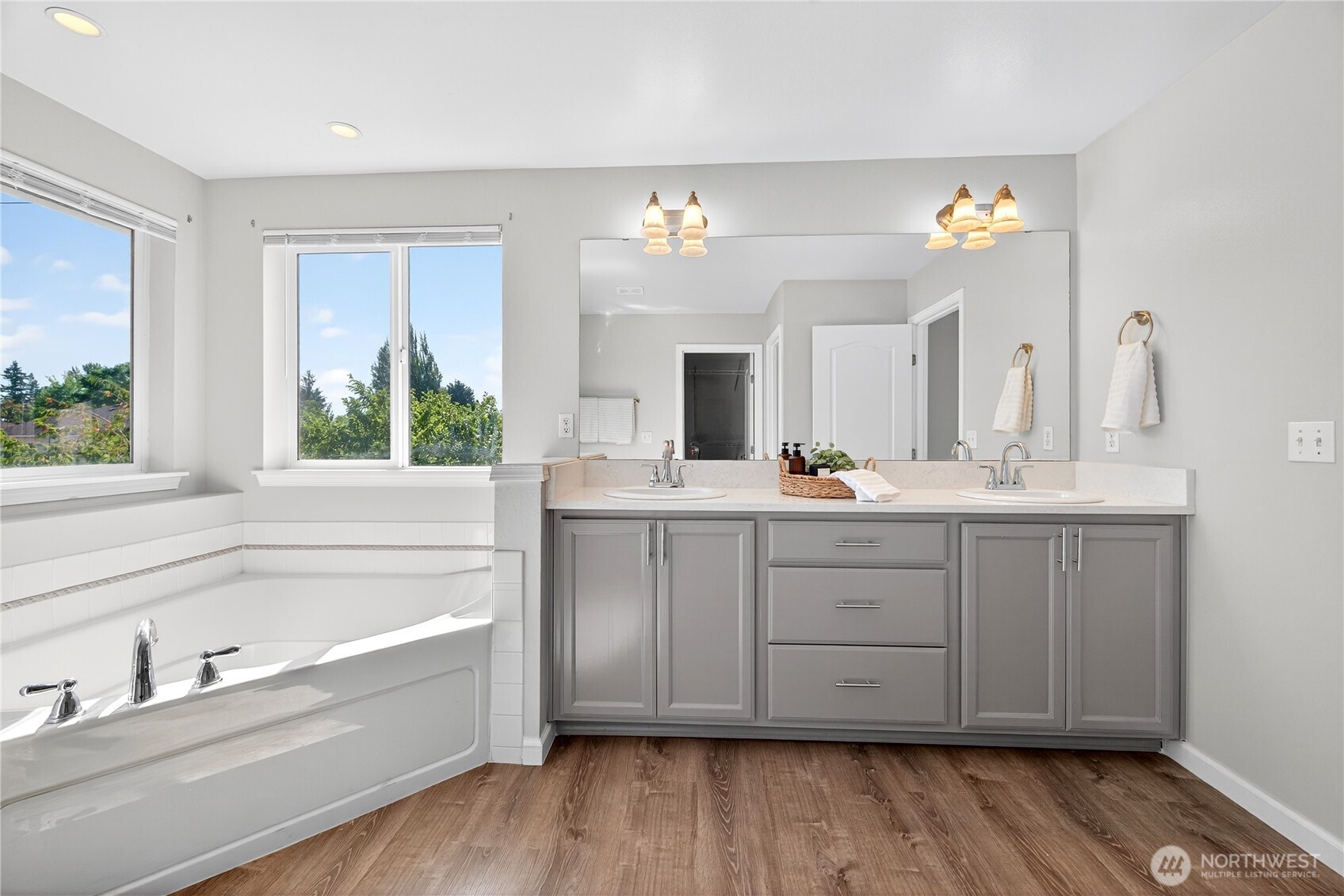 25621 160th Place Southeast Covington, WA 98042 - Photo 16 of 37 a bathroom with a tub double vanity sink and a large mirror