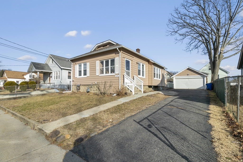 a front view of a house with a yard and trees