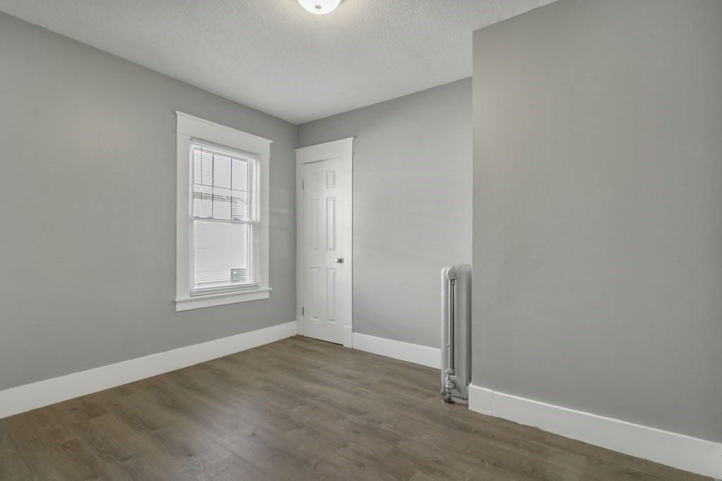 69 Redlands Street Springfield, MA 01104 - Photo 15 of 29 an empty room with wooden floor and a window