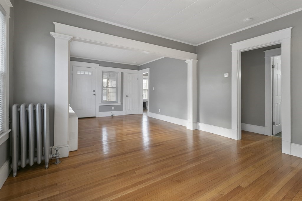 69 Redlands Street Springfield, MA 01104 - Photo 7 of 29 an empty room with wooden floor and windows