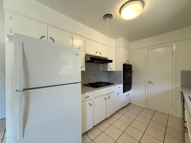 a kitchen with granite countertop a refrigerator and a sink