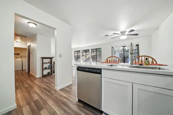 a kitchen with white cabinets and sink