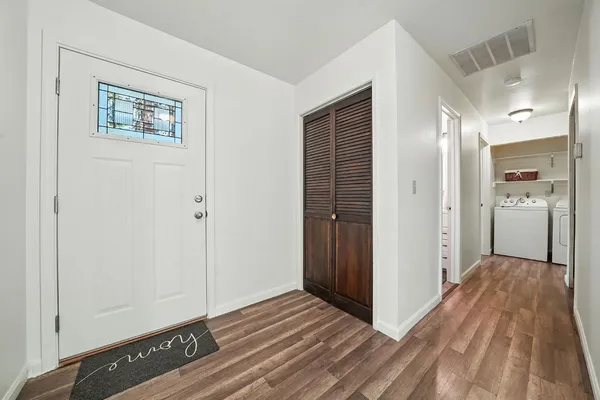 a view of a hallway with wooden floor and closet