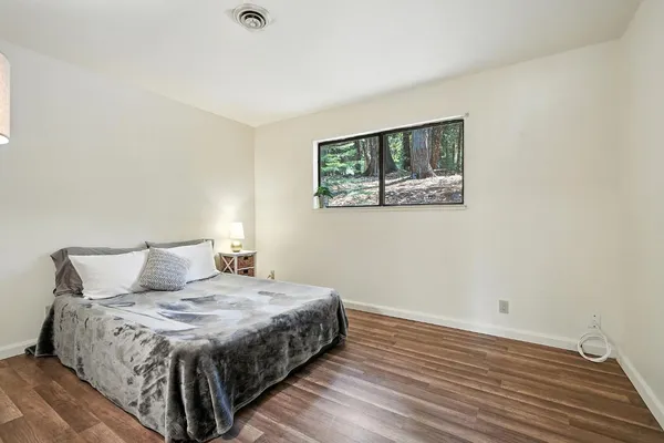 a bedroom with a bed and painting on the wall
