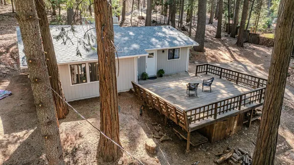 a roof deck with a table and chairs and potted plants