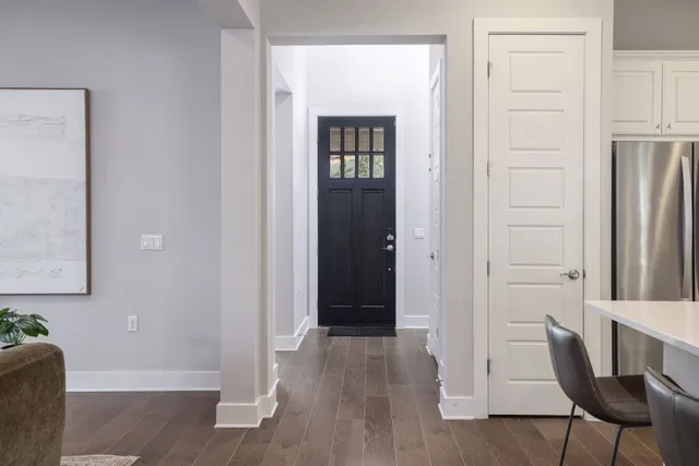 an entryway with a dining room and wooden floor