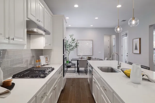a kitchen with a sink a stove and cabinets