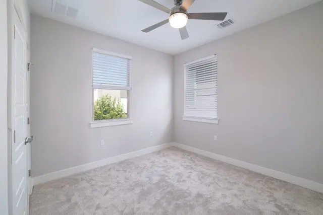 an empty room with a window and a fan