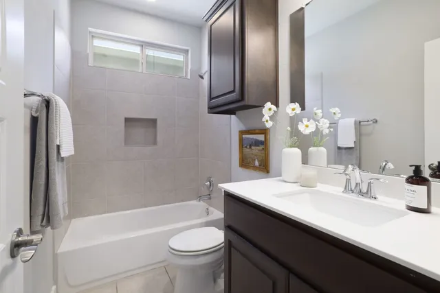 a bathroom with a double vanity sink toilet mirror and bathtub