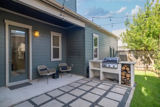 a view of a patio with table and chairs and a barbeque