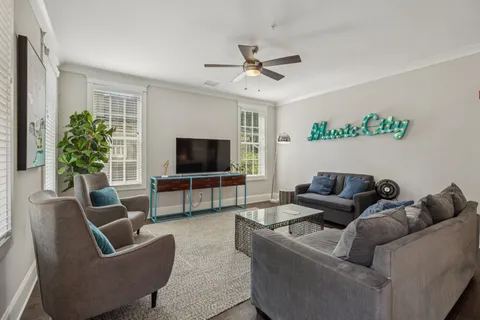 a kitchen with stainless steel appliances a table a stove a sink a dining table and chairs with wooden floor