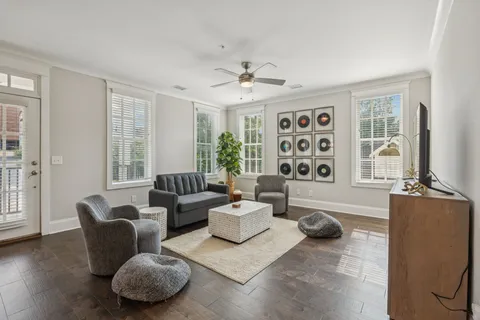 a living room with furniture a flat screen tv and windows