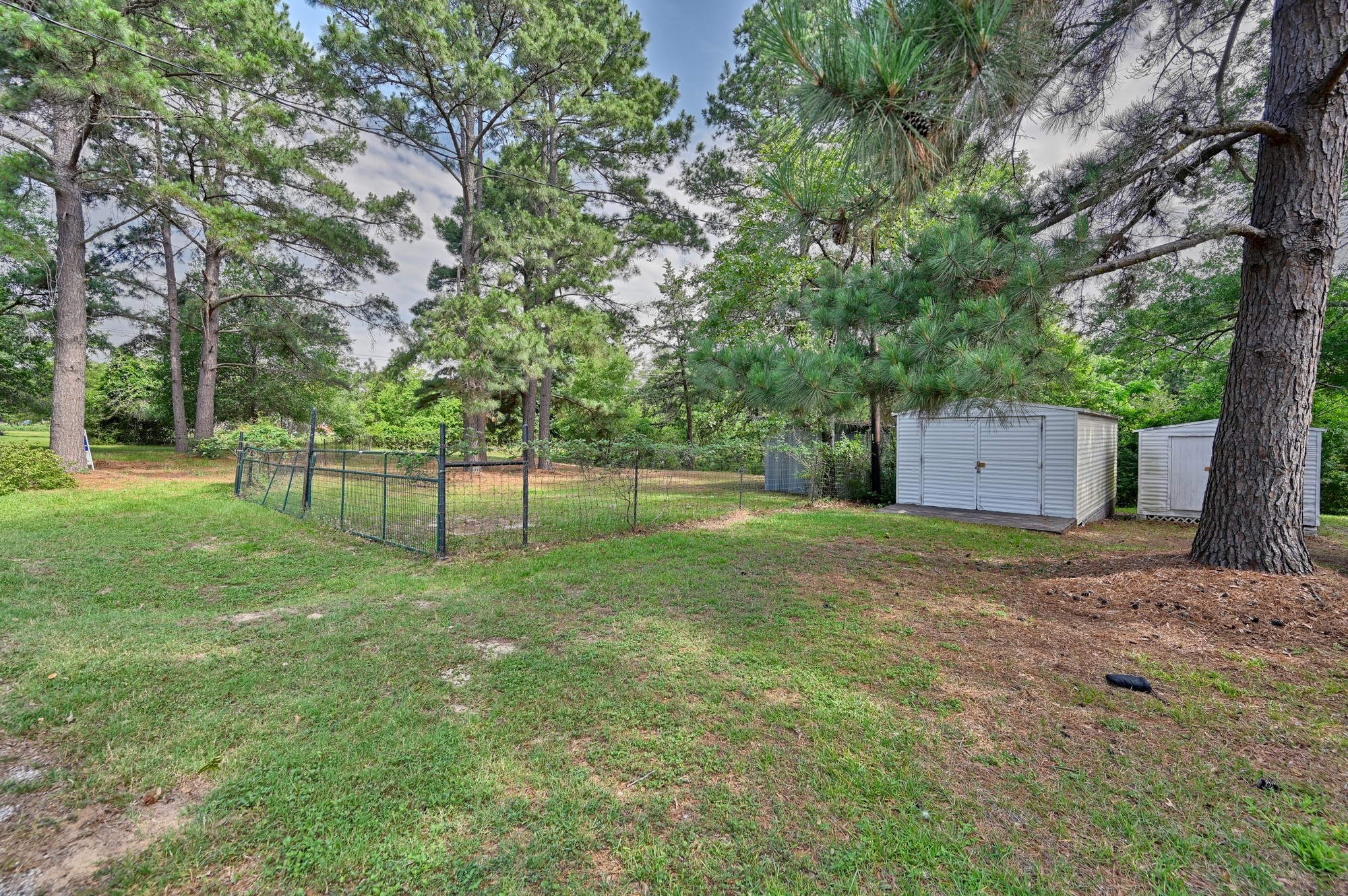 11200 Leisure Road Brenham, TX 77833 - Photo 8 of 23 a backyard of a house with a large tree and wooden fence