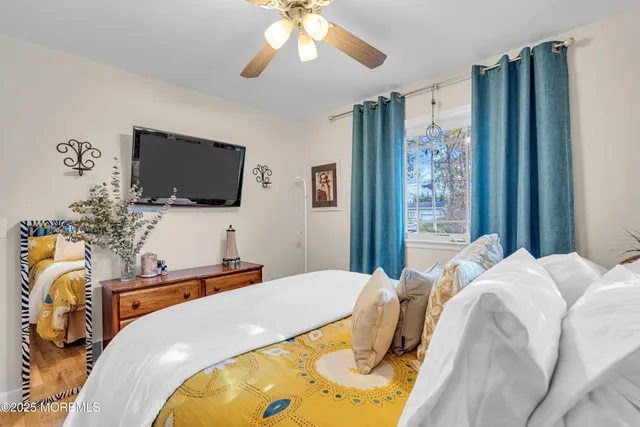 a bedroom with a bed and a flat tv screen on the dresser
