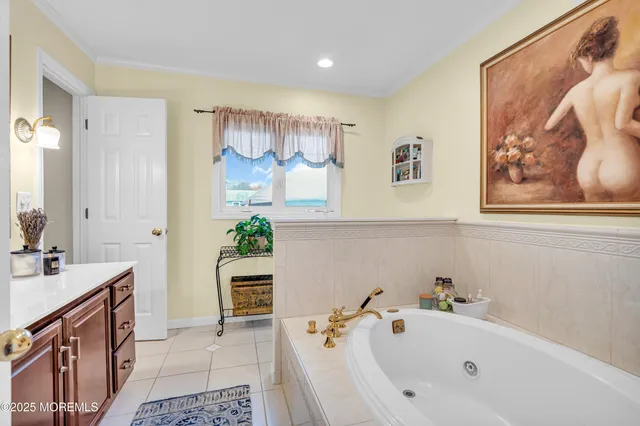 a bathroom with a tub sink and mirror