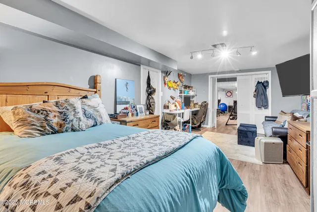 a bedroom with a large bed and a flat tv screen