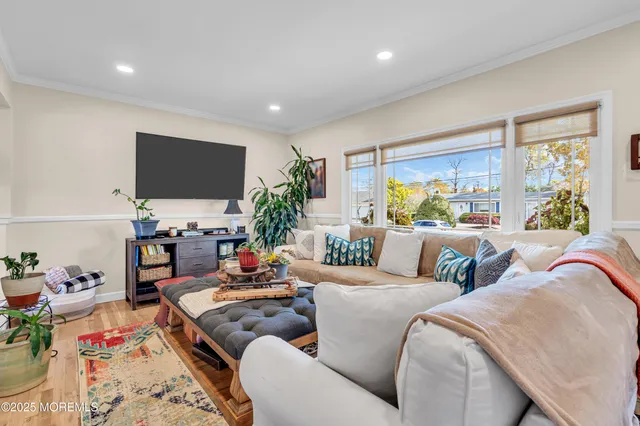 a living room with furniture flat screen tv and a large window