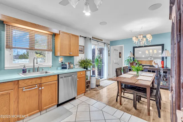 a open kitchen with granite countertop a table chairs stove a sink dishwasher and a dining table with garden view