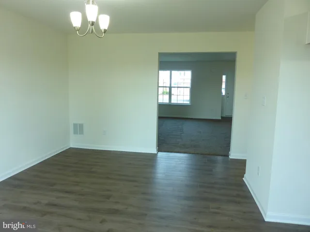 a kitchen with stainless steel appliances wooden floors and white cabinets