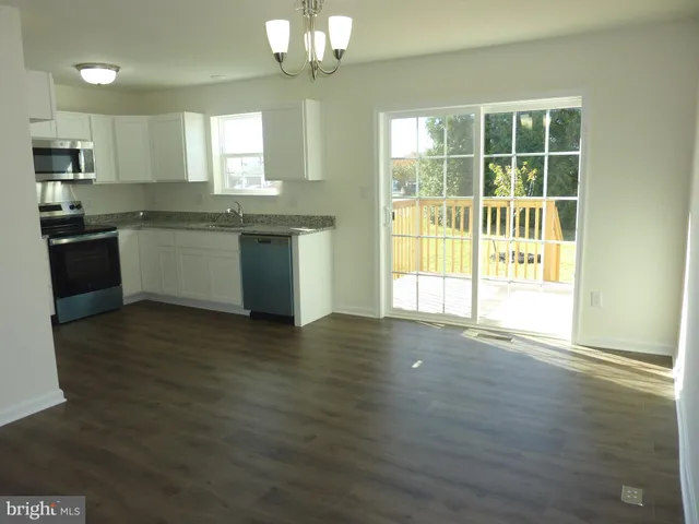 a kitchen with granite countertop white cabinets and stainless steel appliances