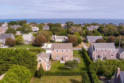 an aerial view of a house with a garden and large trees