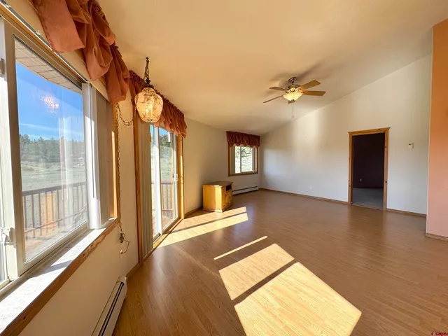 a view of a bedroom with a window and wooden floor