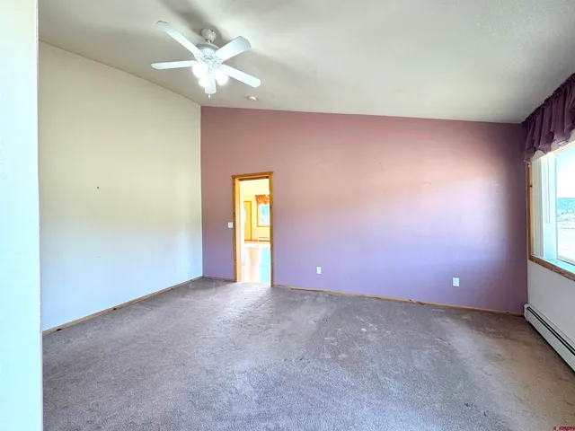 an empty room with a window and a kitchen