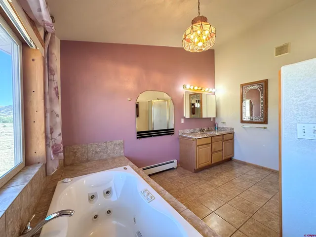 a bathroom with a tub sink and mirror