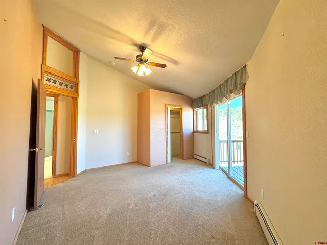 a view of a big room with windows and chandelier fan