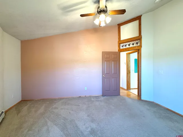 an empty room with a ceiling fan and a window