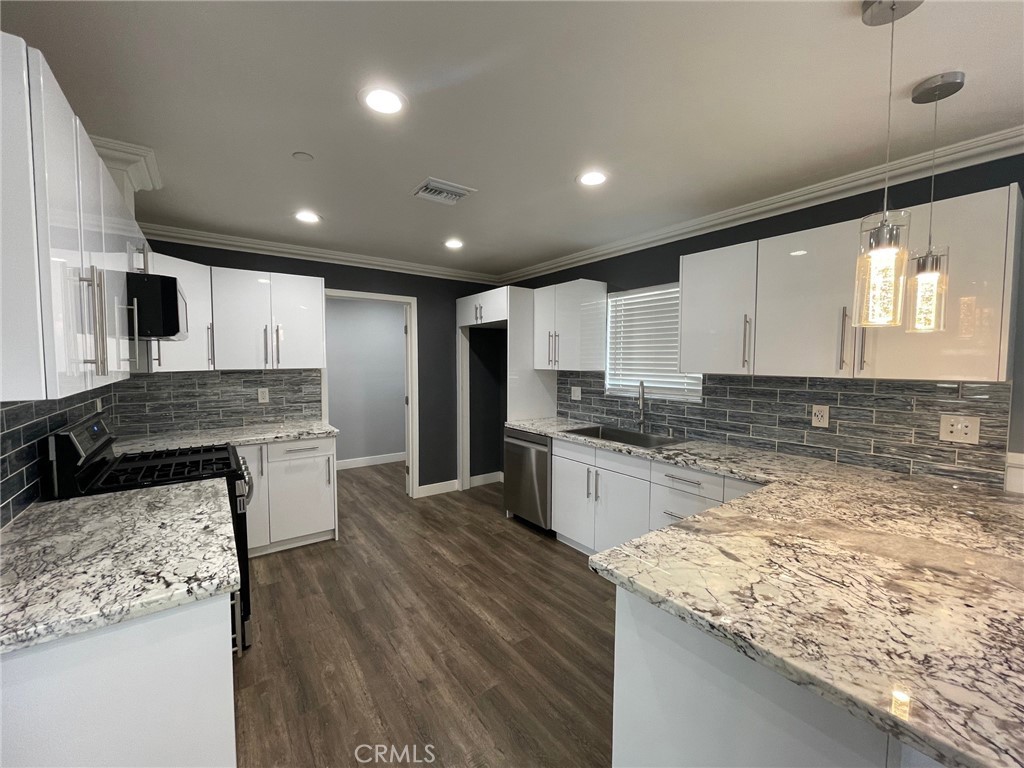 10055 East Ave R 10 Littlerock, CA 93543 - Photo 7 of 31 a large kitchen with granite countertop a large counter top stainless steel appliances and cabinets