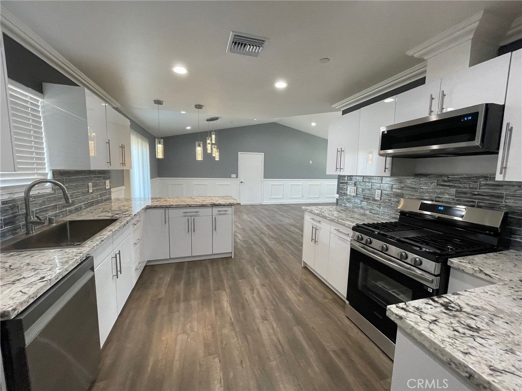 10055 East Ave R 10 Littlerock, CA 93543 - Photo 8 of 31 a large kitchen with a stove top oven a sink a counter space and cabinets