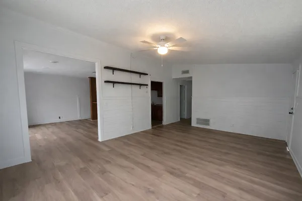 a view of an empty room with wooden floor