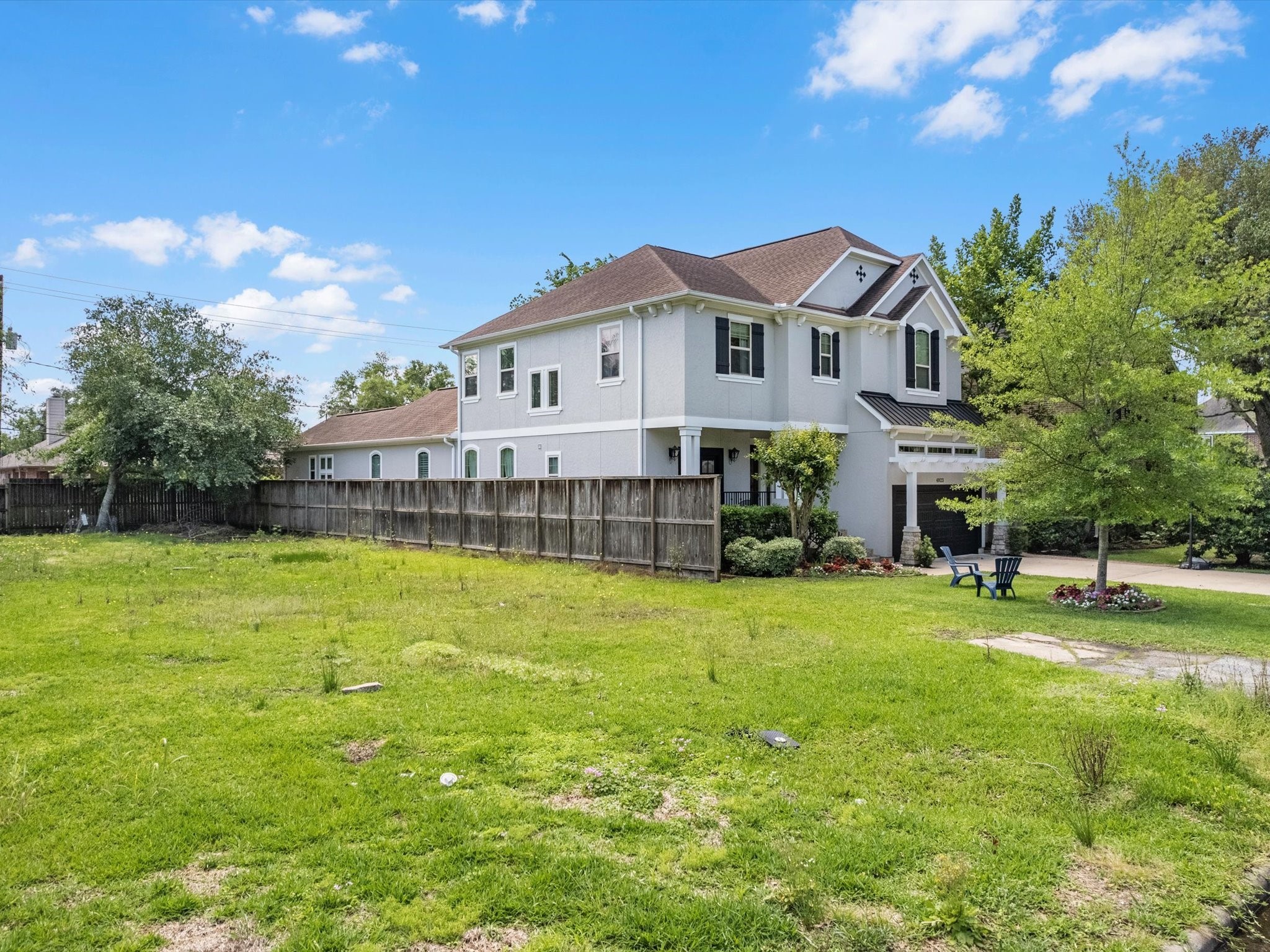 4921 Chestnut Street Bellaire, TX 77401 - Photo 7 of 9 a view of a house with a big yard and large trees