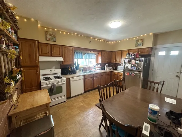 a kitchen with a table chairs microwave and cabinets